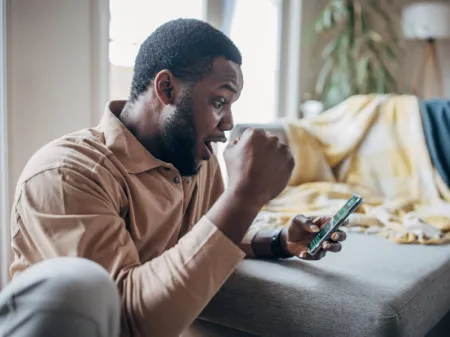 Parieur heureux après un gain sur smartphone image libre de droit