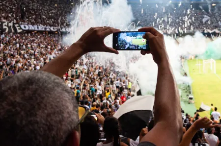 Supporter filmant l’ambiance d’un match au stade image libre de droit